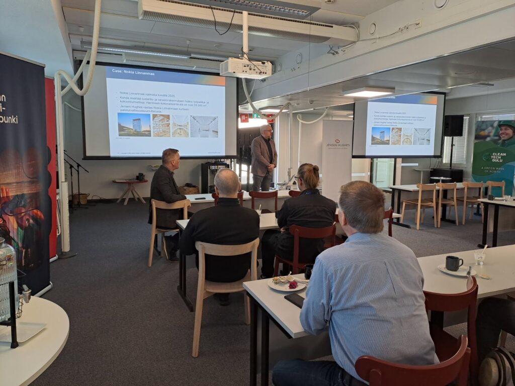 People sitting with coffee and listening to a presentation.