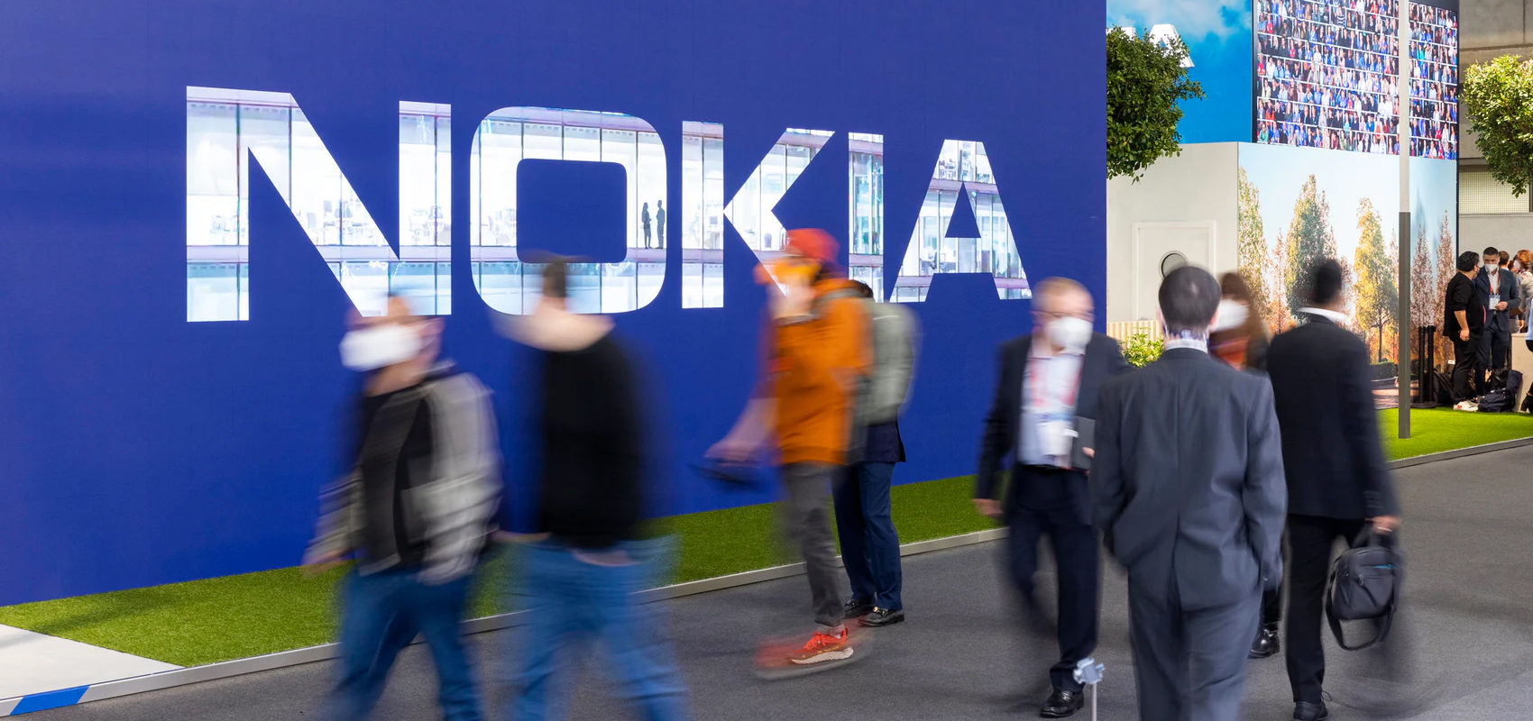 Ihmisiä kävelee Nokia-kyltin ohi