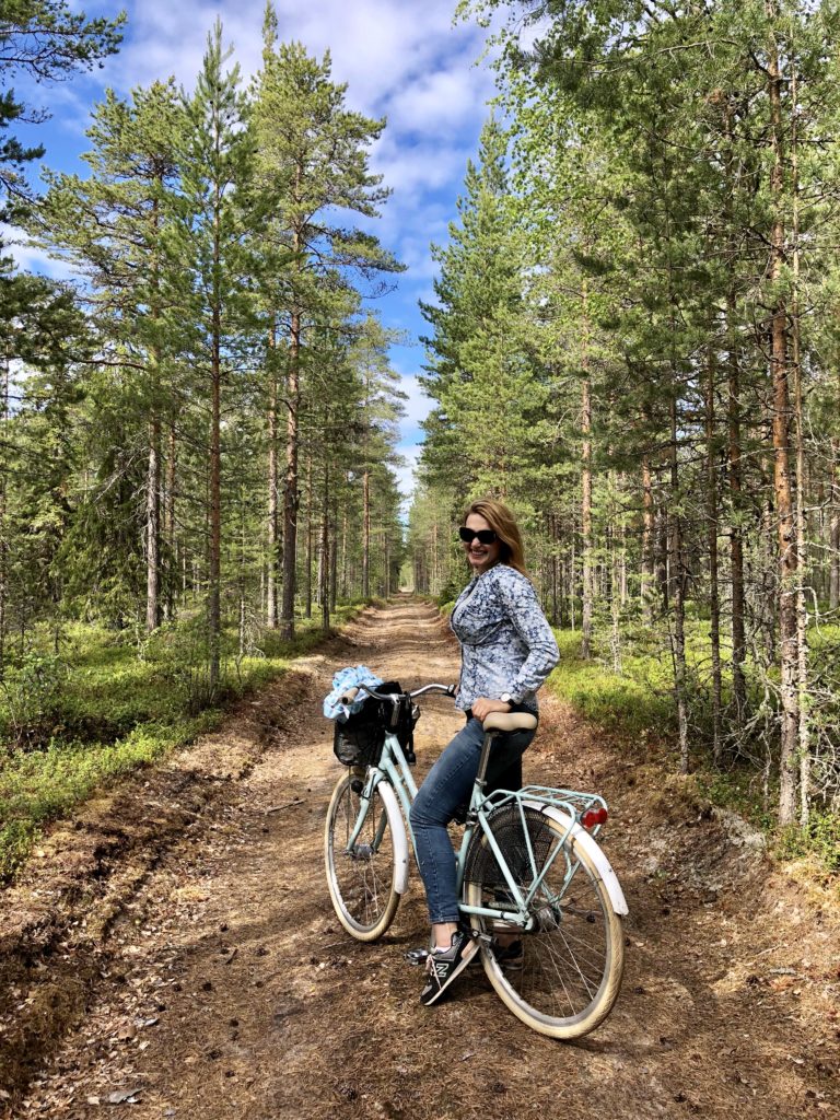 Nainen pyöräilee metsässä