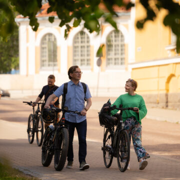 Ihmisiä taluttamassa pyöriä Oulussa